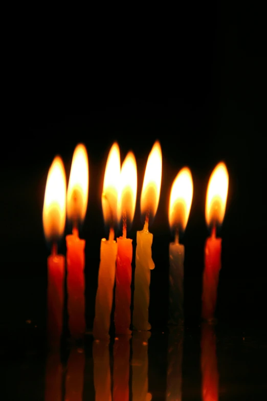 multiple candles lit in the dark one on each side