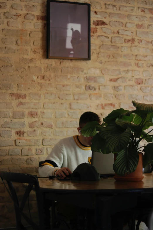 a man sitting at a table while looking through his laptop