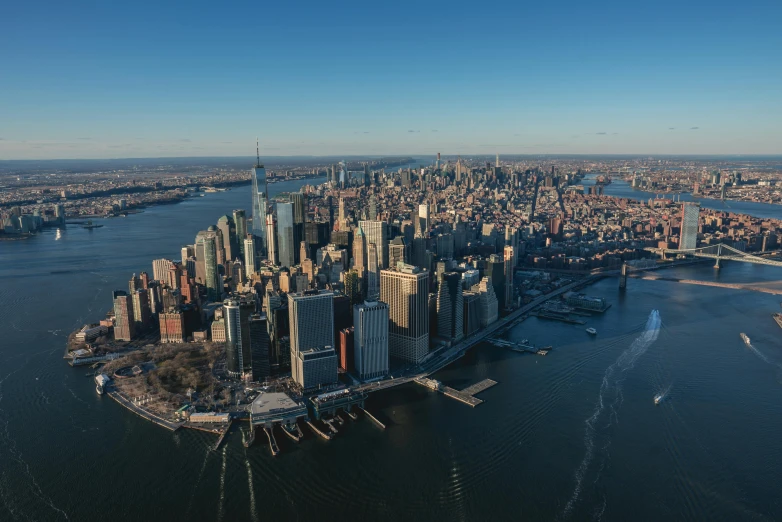 a city skyline on an island with a large bridge over looking the water