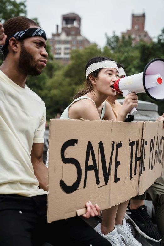 people with a sign that says save the planet