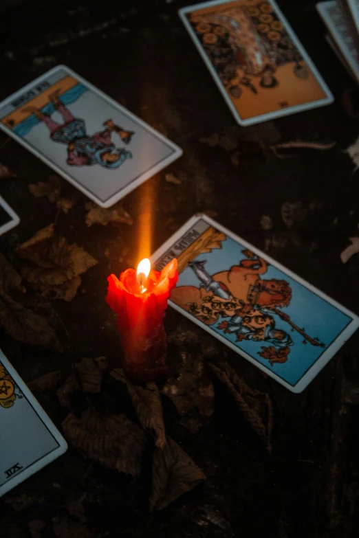 a candle is lit in the dark with seven card deckes laid out