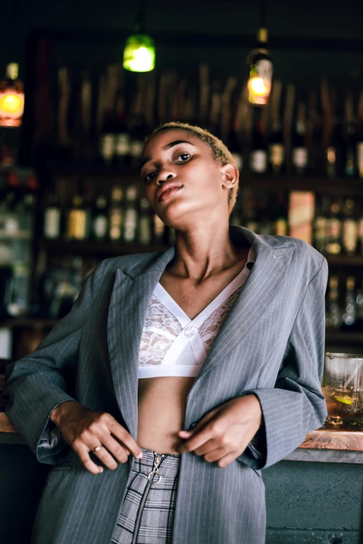 a woman standing at the bar with her hands on her waist