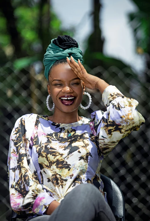 a smiling woman with a green head scarf on