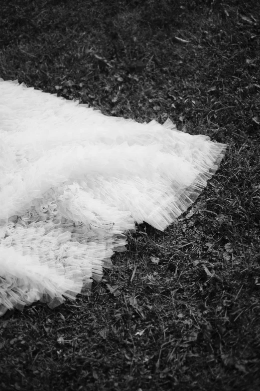 a white piece of material sitting on top of a grass covered field