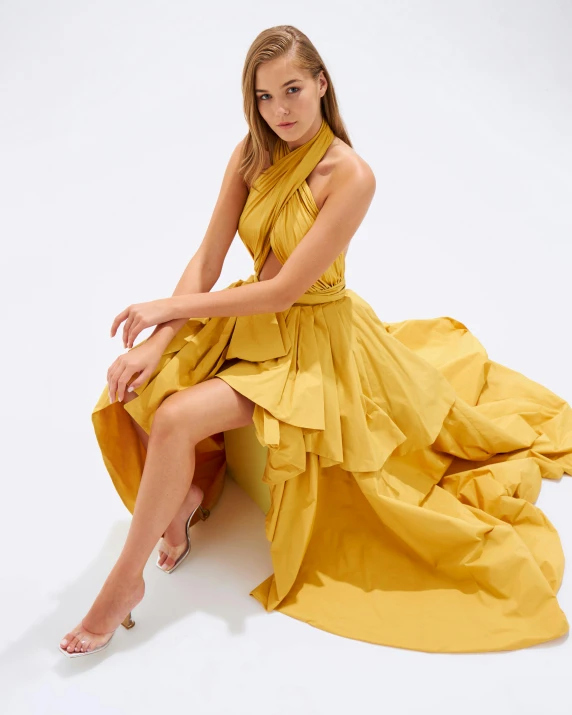 the young woman is posing in the yellow dress