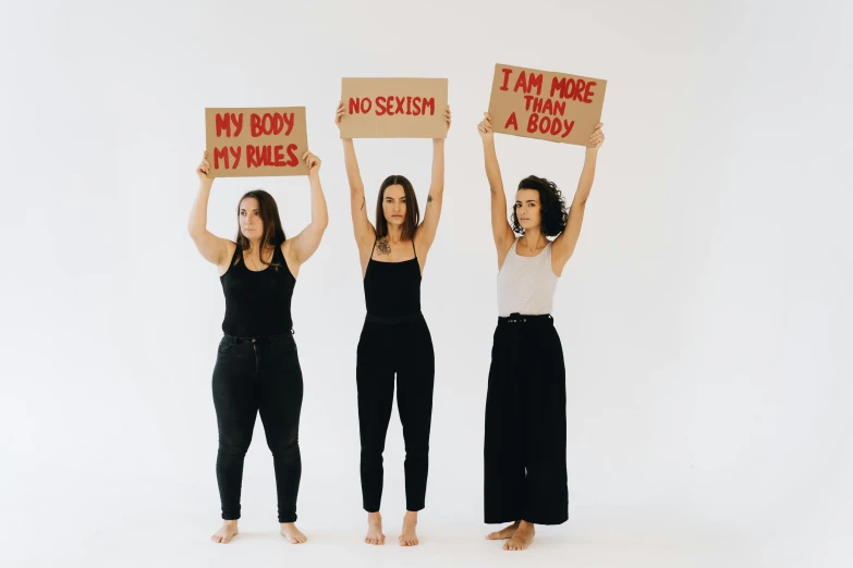 three women holding up cardboard signs that read, i am not angry, not i am jesus