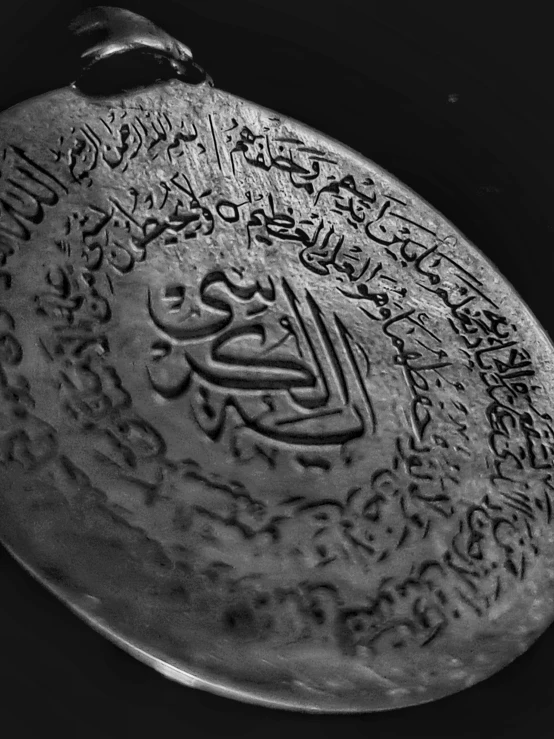 an ornate metal plate with multiple arabic writing