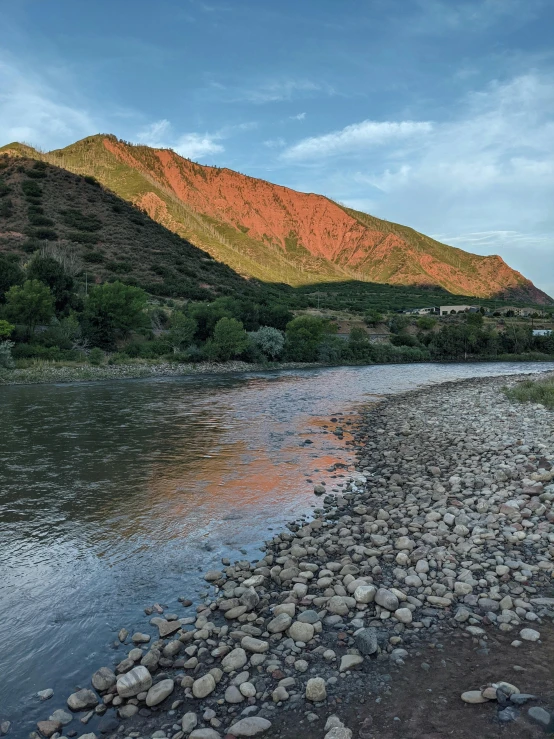 the mountain view of a body of water, rocks, and mountains