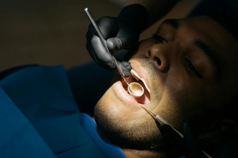 man at the dentist examining a hole in his teeth