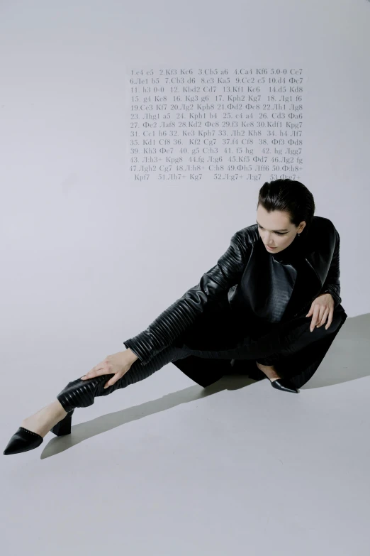 a man sitting on the ground while dressed in a leather suit