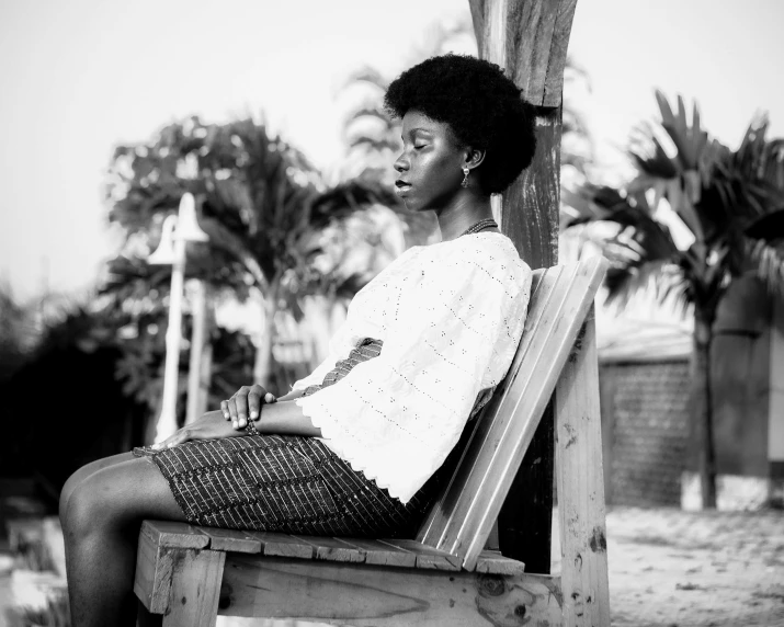 woman sitting on a wooden bench and posing for the camera