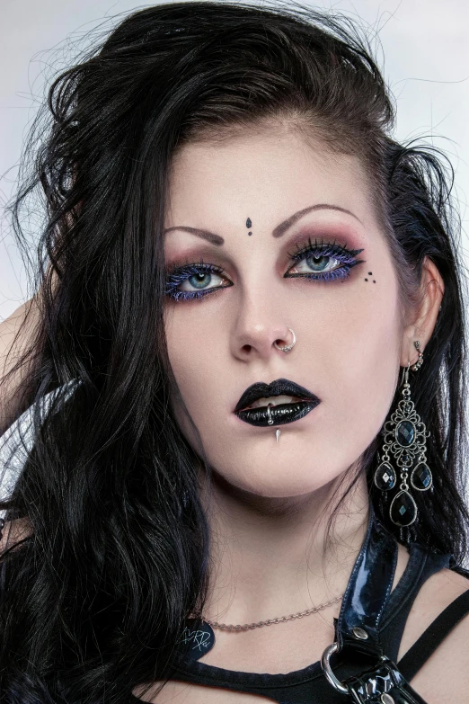 a woman wearing makeup on her face with a goth look