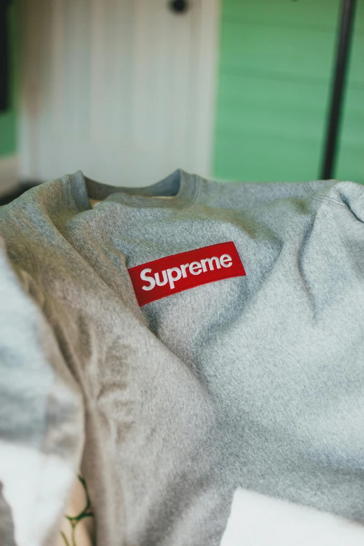 a grey supreme t shirt with the supreme sticker