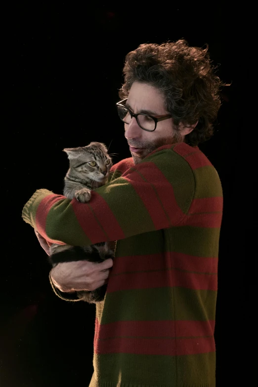 a guy holding a cat and looking back