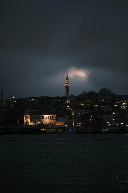 dark skies and some buildings along the water