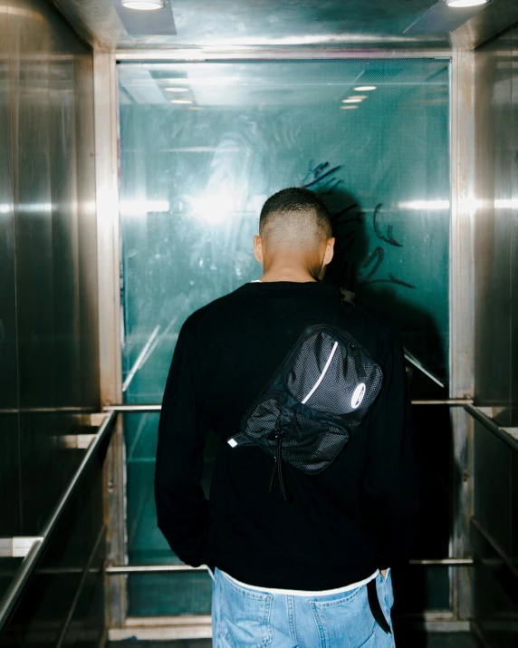 a man wearing headphones looking down an elevator