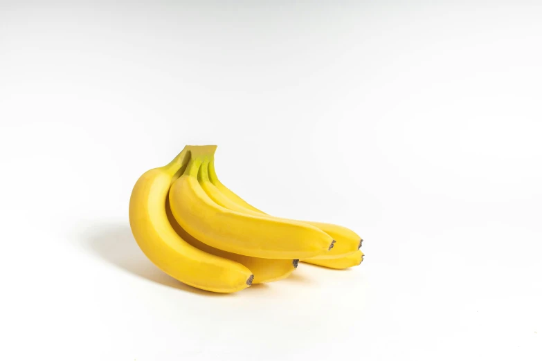 several bananas sitting side by side on a white background