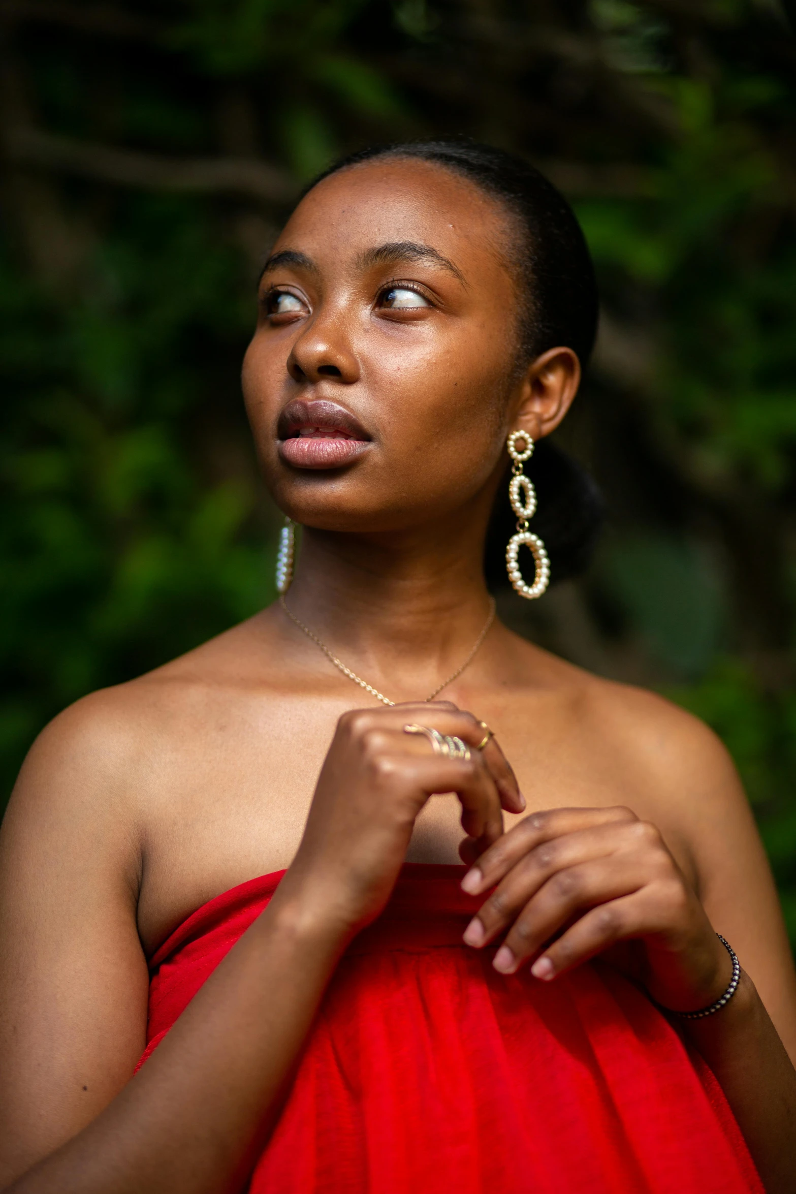 a beautiful young woman in red dress looking up