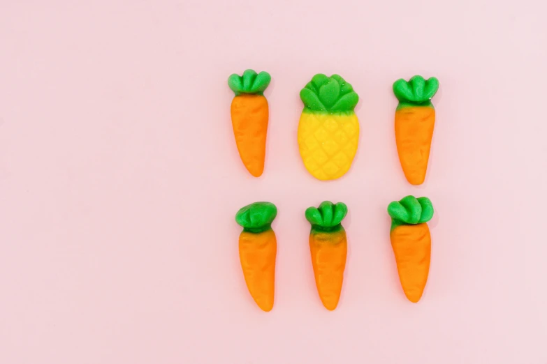 four tiny plastic carrots sit side by side