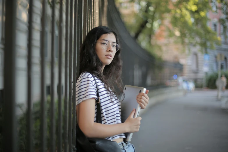 a woman with glasses holding an electronic device