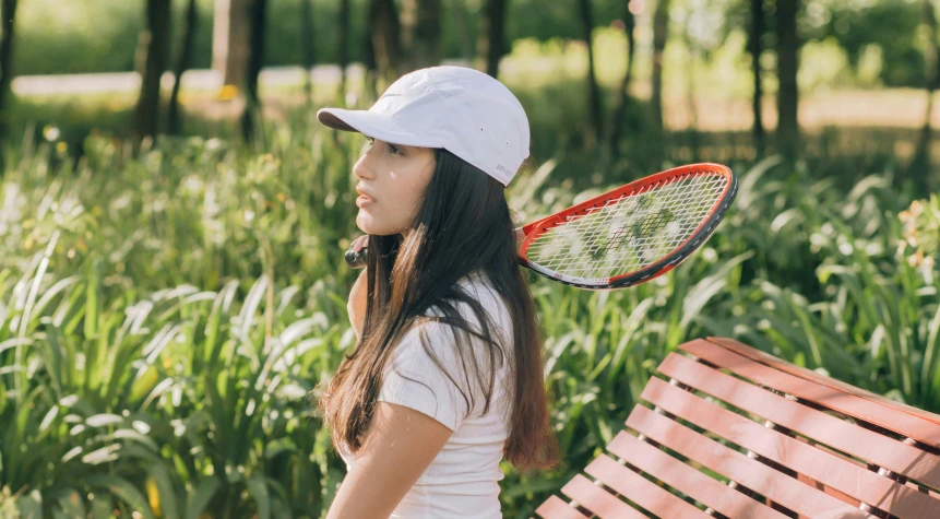 the girl in the hat is holding a tennis racket