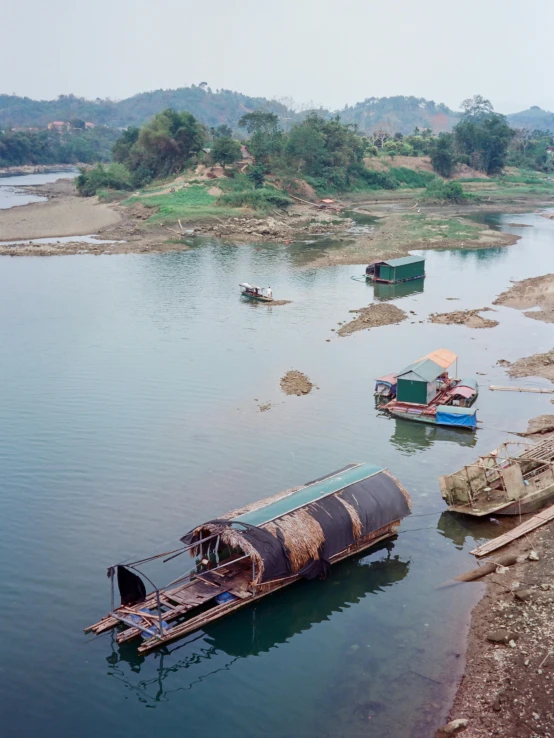 two boats are in the river near some other small structures