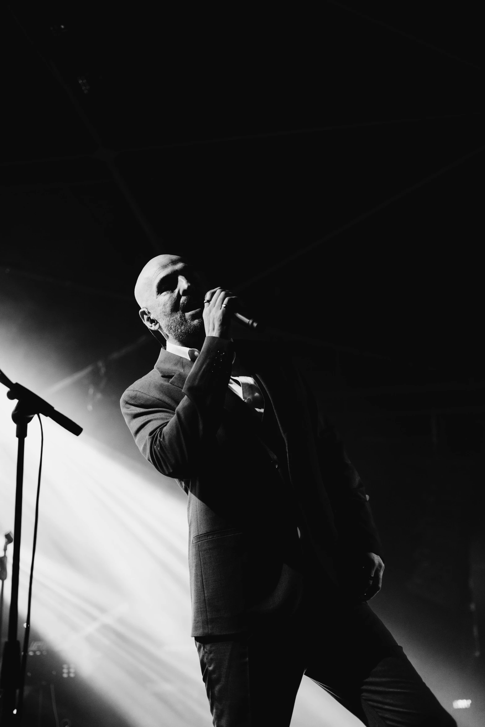 a man standing in front of microphone on stage