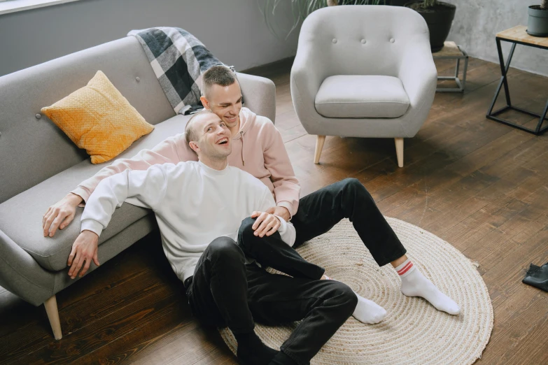 two men sitting on the floor of a living room