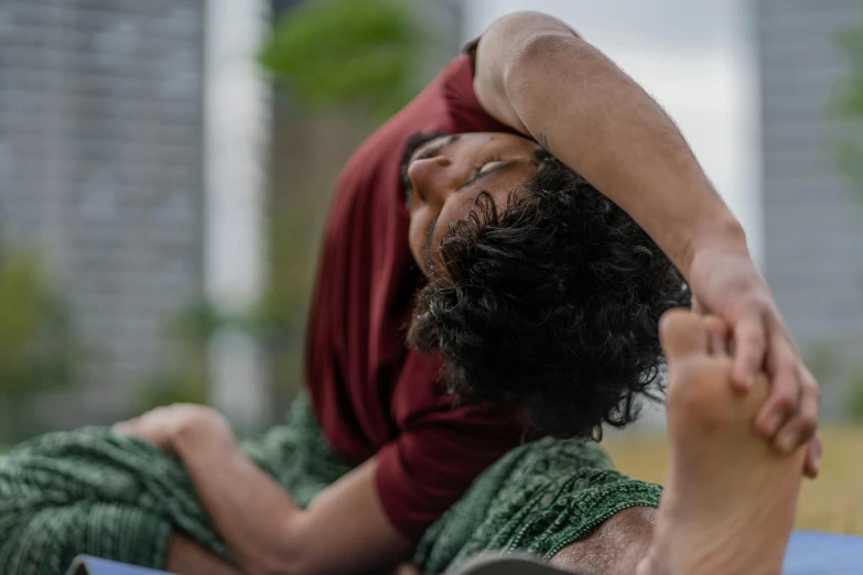 a man is stretching while laying down on the ground