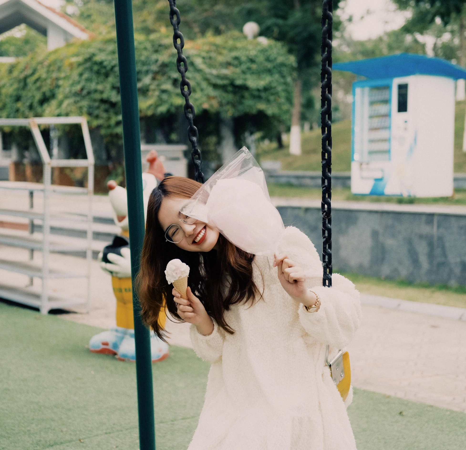 a little girl wearing a white dress holding an ice cream cone