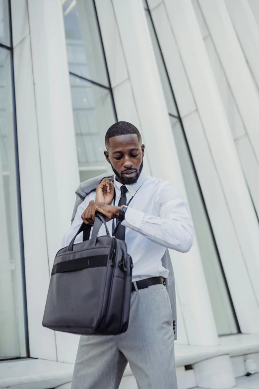 a businessman holds his briefcase while walking outside of a building