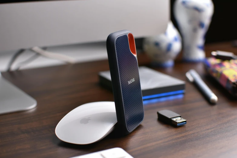 a computer mouse, cell phone and other electronics sitting on a desk