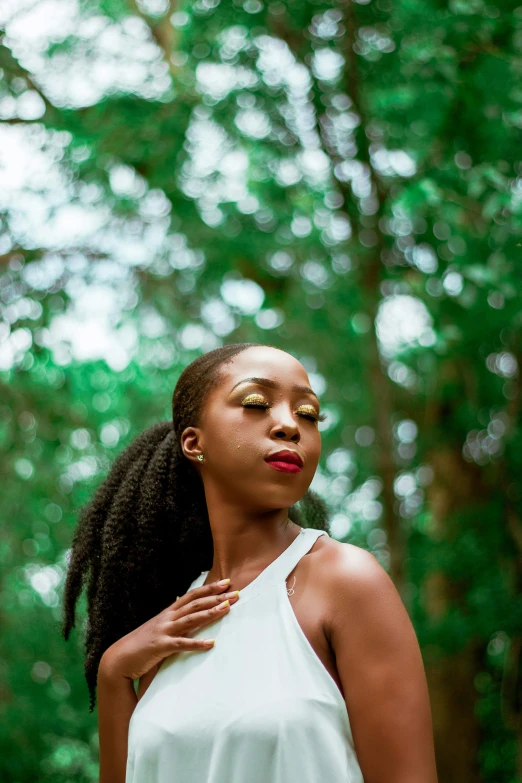 an afro woman standing in a forest with long black hair