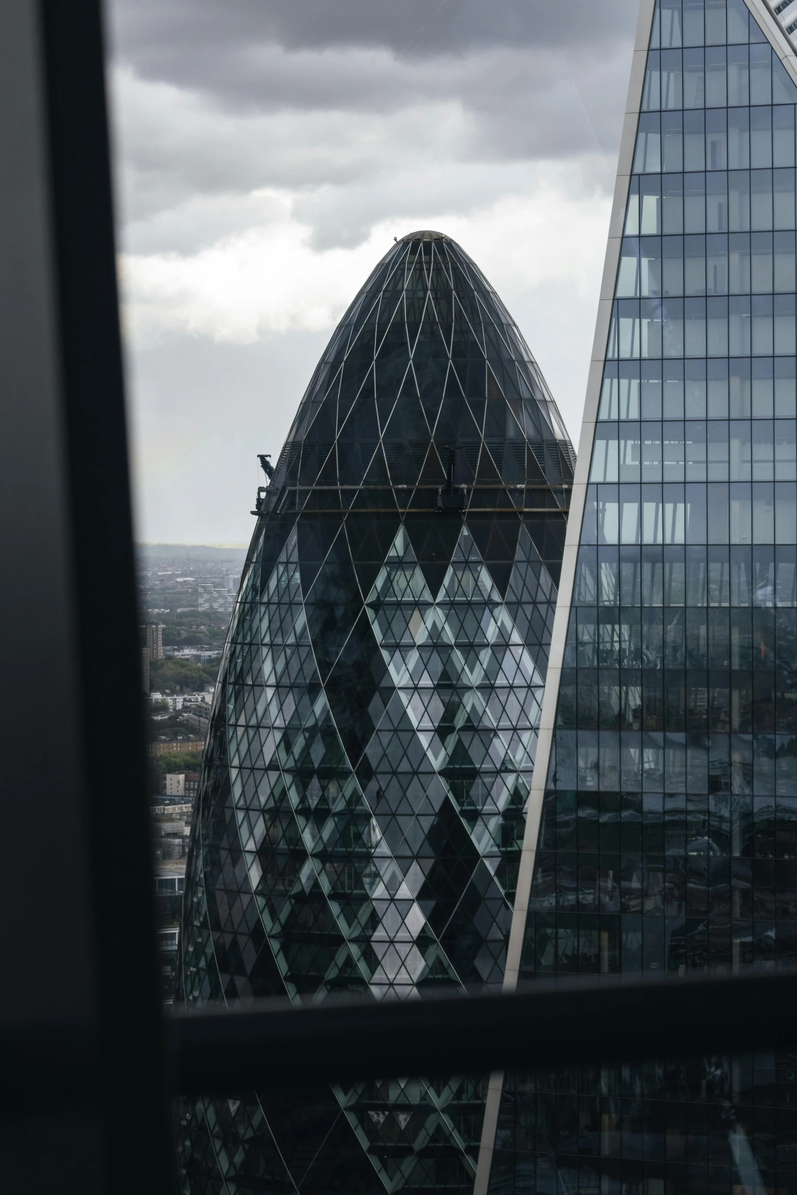 two skyscrs stand side by side under cloudy skies