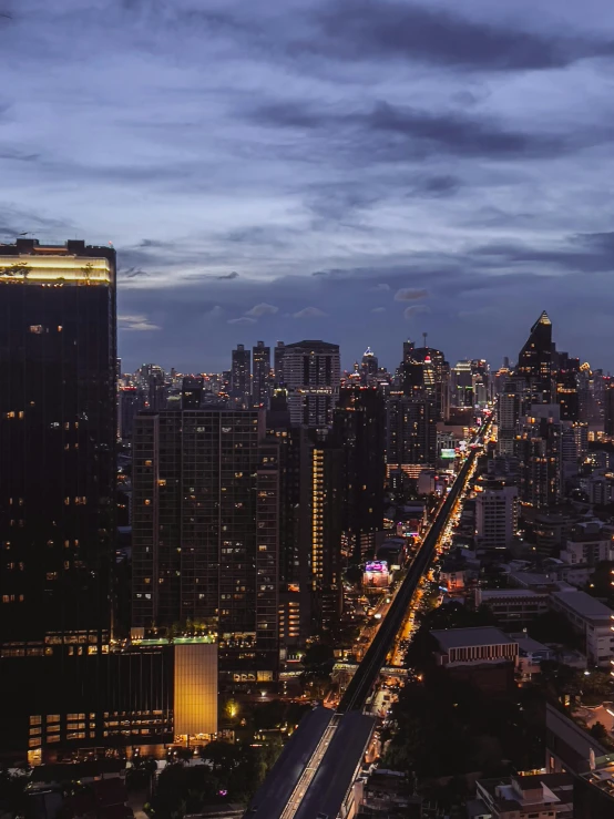 a long stretch of highway next to tall buildings at night