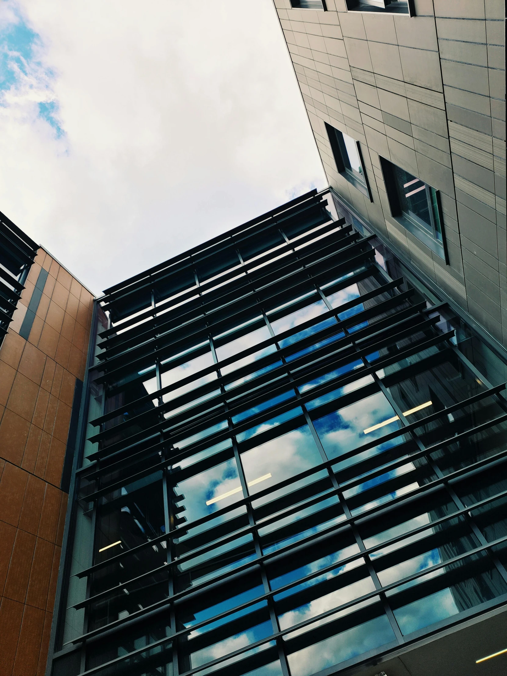 a tall building with many windows and sky reflected in it