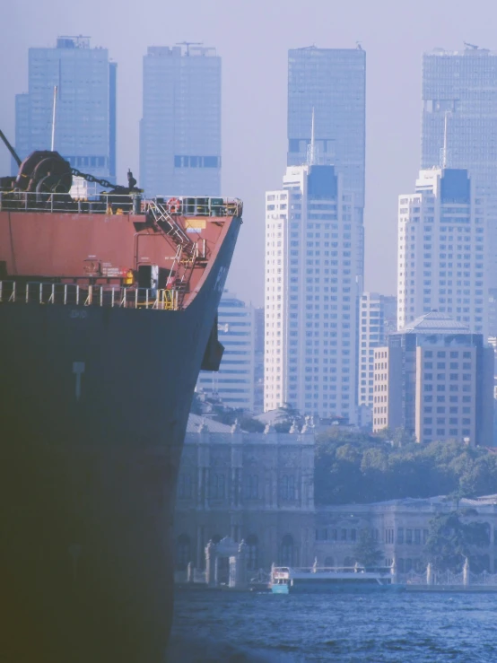 a boat in the water near a city with tall buildings