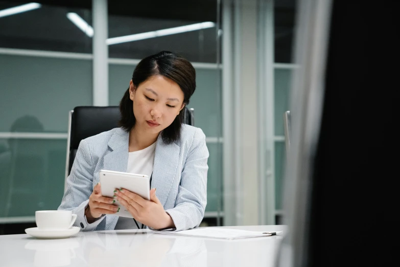 woman looking at her ipad and writing soing