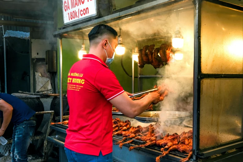 a man on a food cart has a bunch of food being cooked