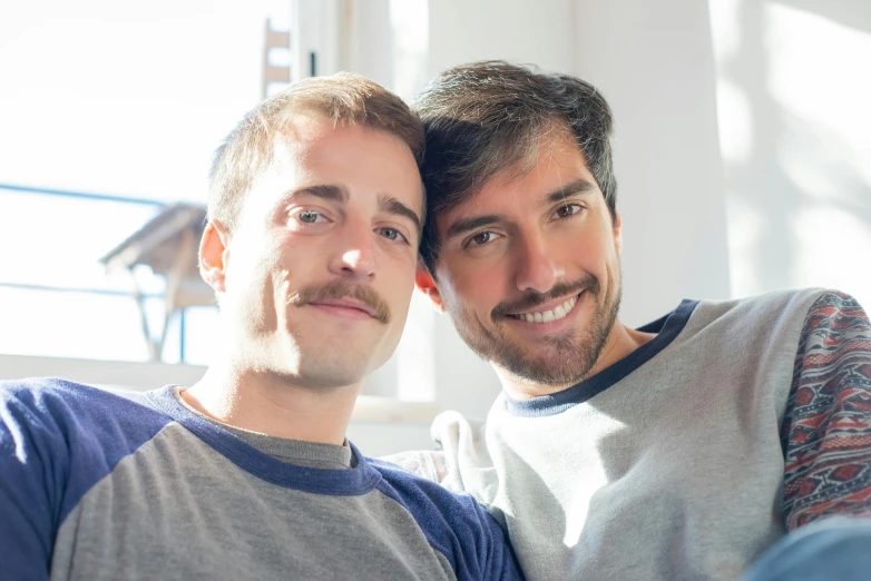 a man sitting next to another man with his arm around his neck