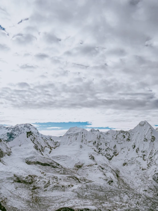 a mountain range covered in snow and a bird flying over it