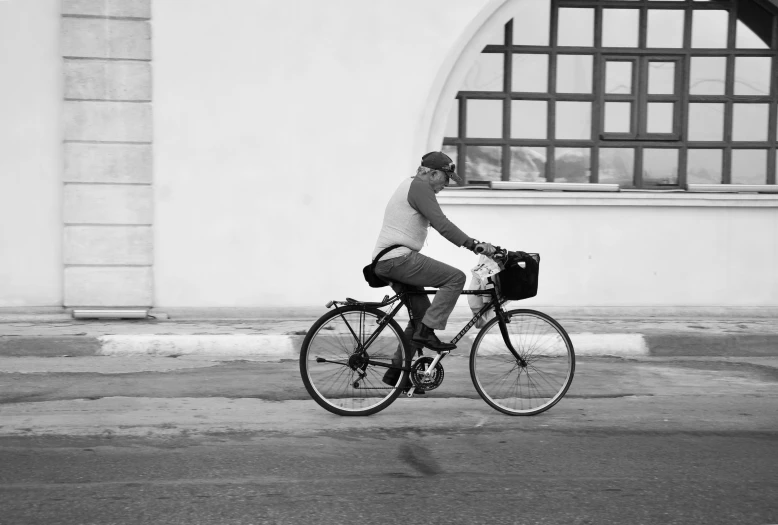 man on a bicycle with helmet riding down the street