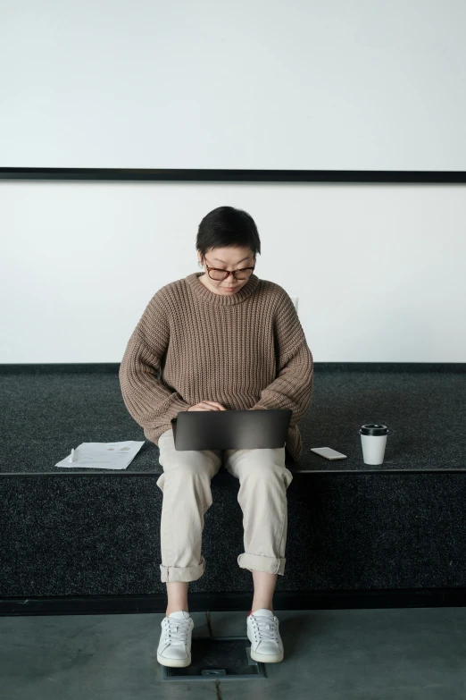 a man sitting down with his feet on his laptop