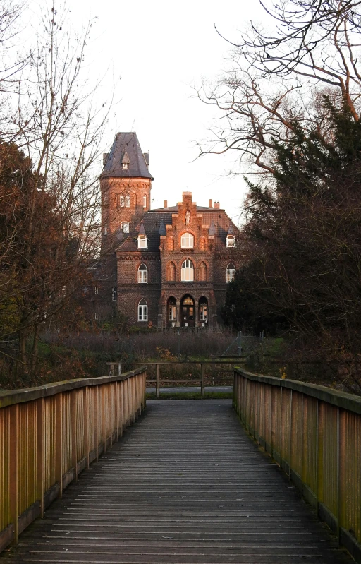 an old house and bridge in a wooded area