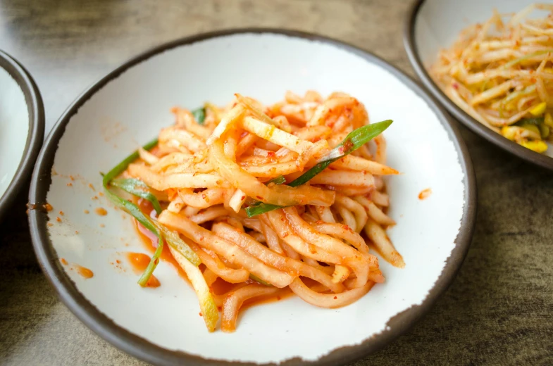 two white bowls filled with food on top of a table