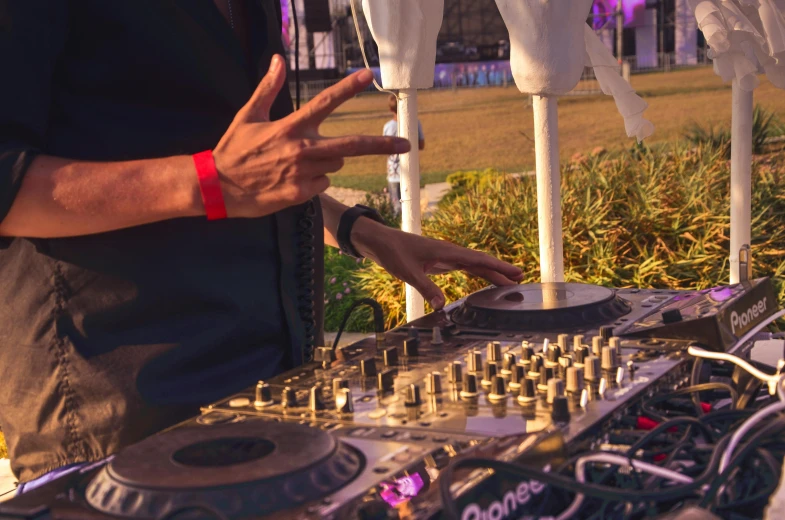 man in black shirt standing next to a dj set