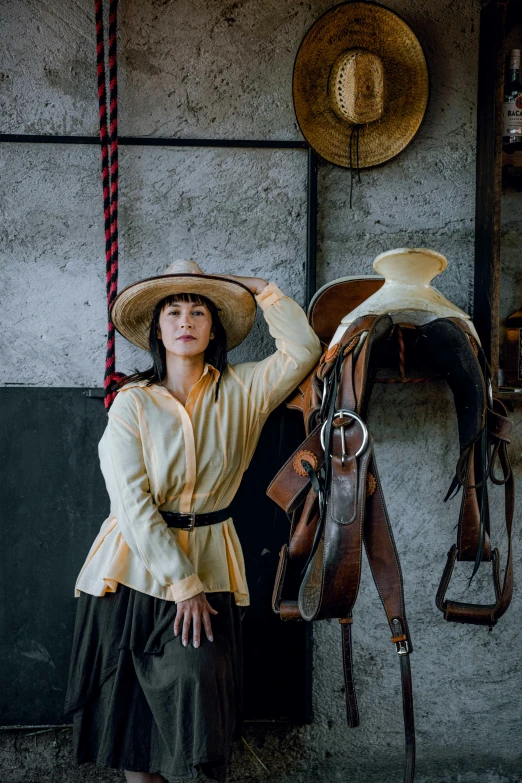 woman leaning on her saddle and posing with her horse