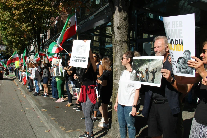 people holding signs on the side of the street