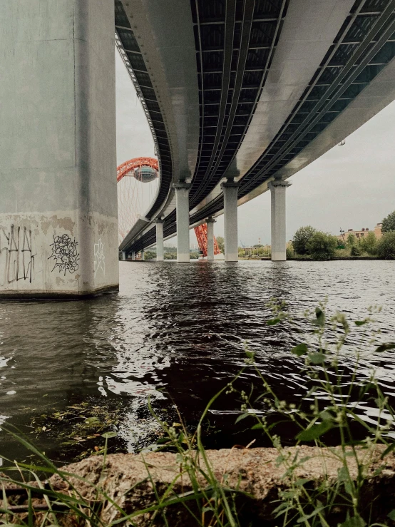 some water underneath a bridge with graffiti on the side