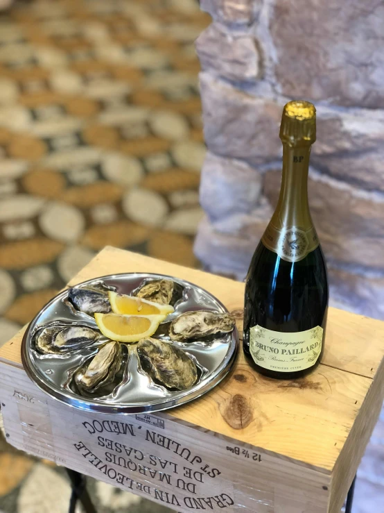 a plate on top of a table next to a bottle of champagne